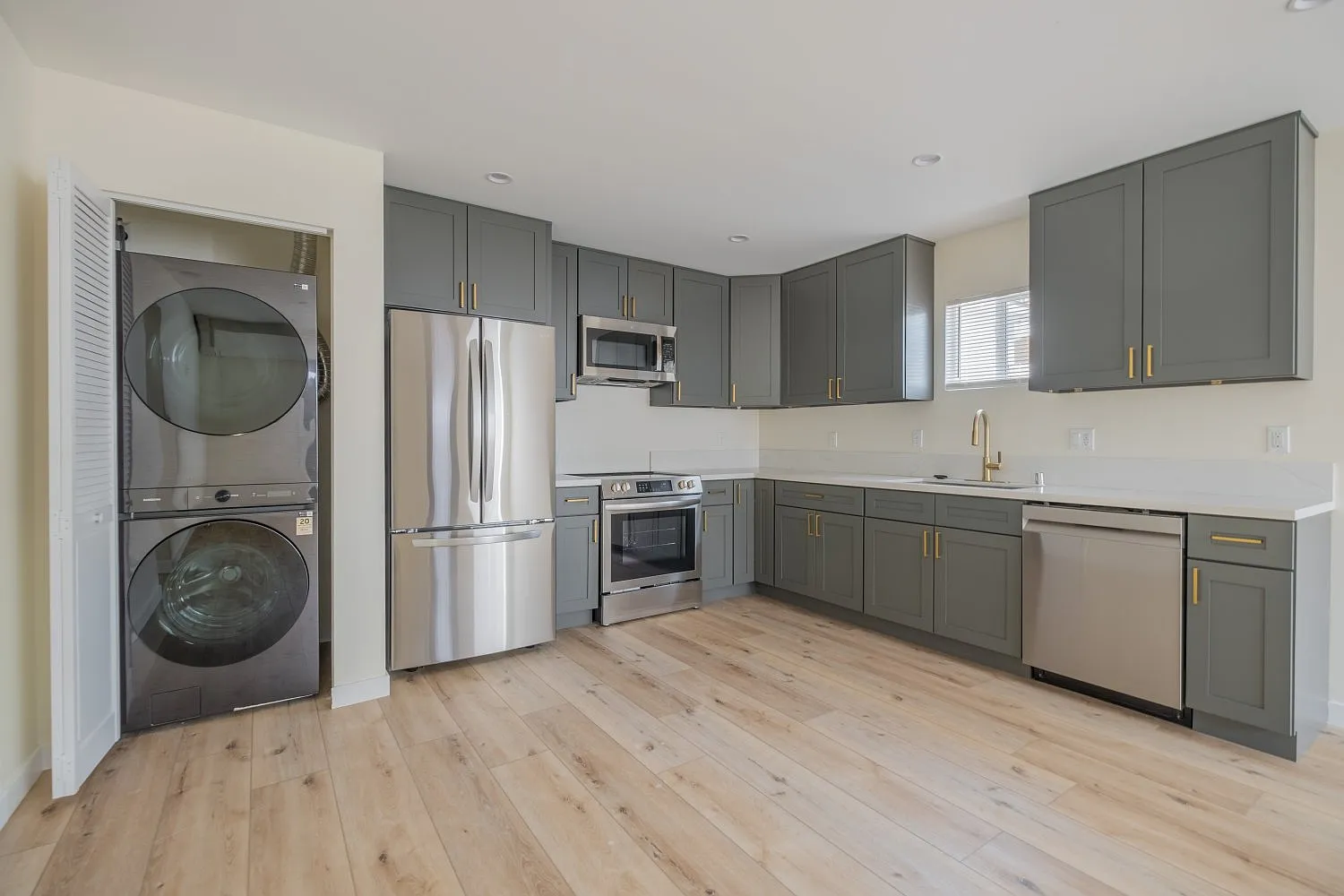 Standard ADU kitchen finish with stacked washer/dryer and open layout